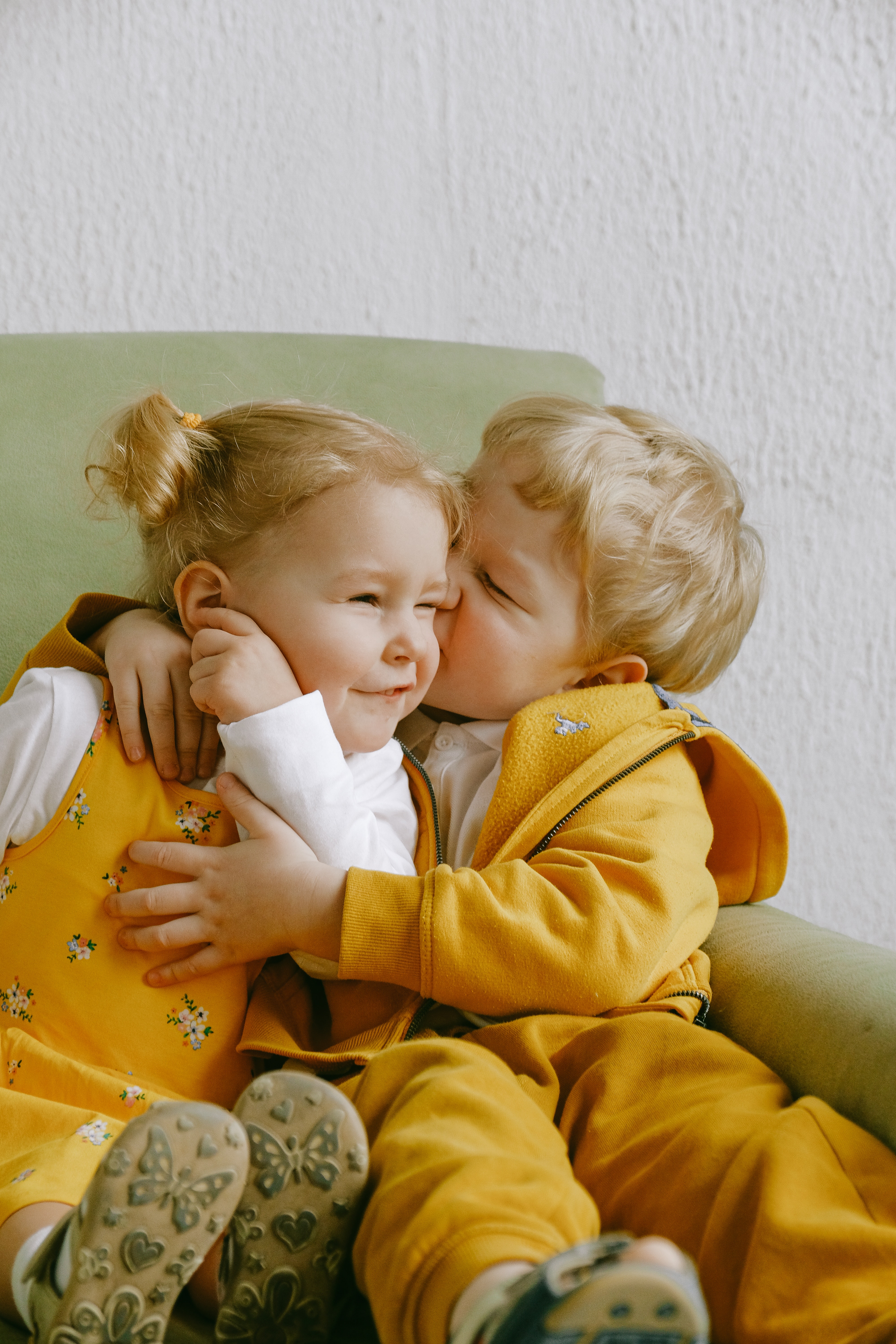 cheerful little siblings hugging in armchair at home 3771605